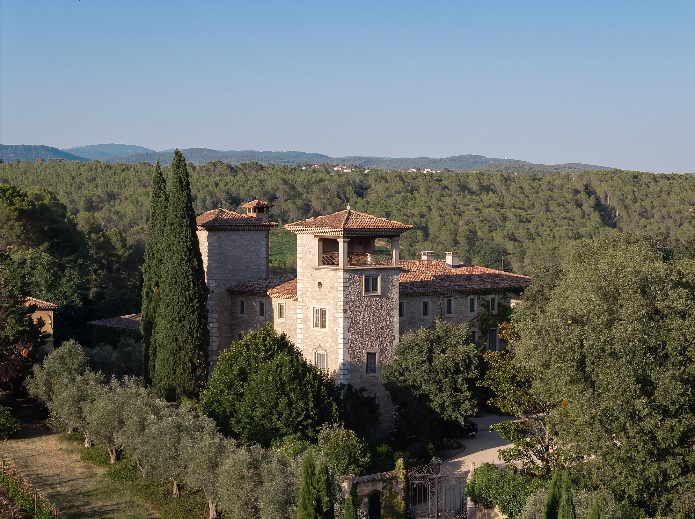 Vue aérienne d'un domaine provençal en pierre entouré de cyprès, illustrant l'approche de Dix Louvois Paris